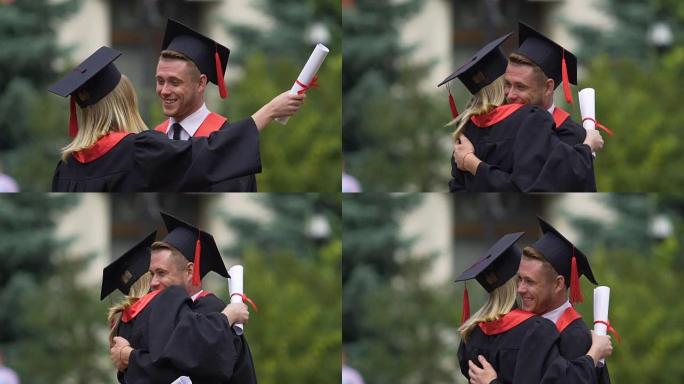男女毕业生学帽拥抱，朋友抱歉说再见
