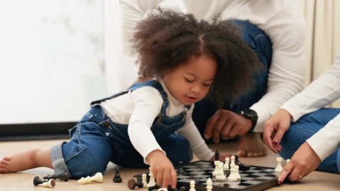 一个顽皮的女儿正在协助她的多种族新手父母清理棋盘以进行新一轮比赛。