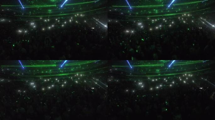 歌迷在音乐会上享受奇妙的灯光效果，惊人的照明表演