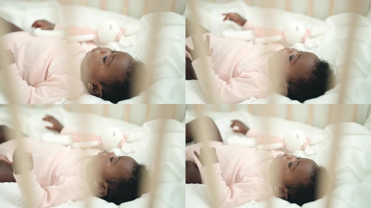 非裔美国人婴儿躺在摇篮上，在卧室里表情轻松