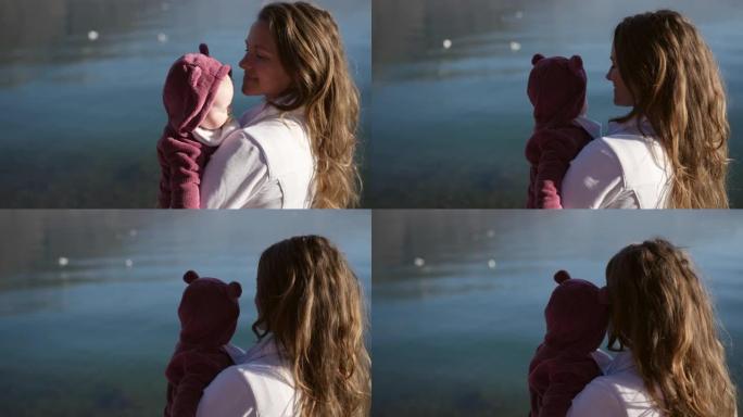 一个年轻的母亲和婴儿在高山湖岸观光的特写镜头