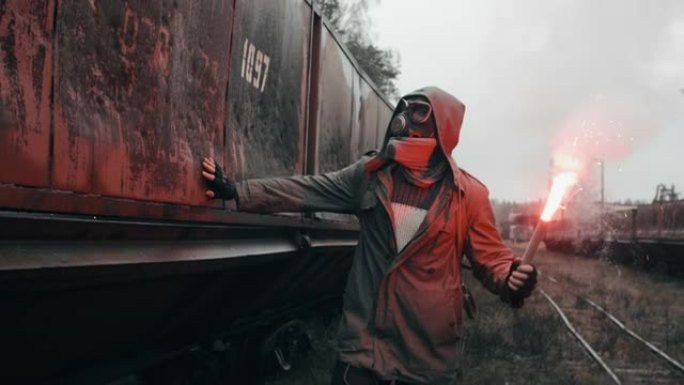 戴着防毒面具的蒙面男子，在被毁的火车站的马车上，手里拿着燃烧的信号火