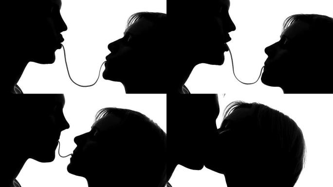 女人和男人在约会时吃意大利面和温柔接吻的剪影