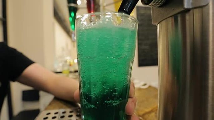 男子加入水绿色糖浆并搅拌，混合配料，派对鸡尾酒