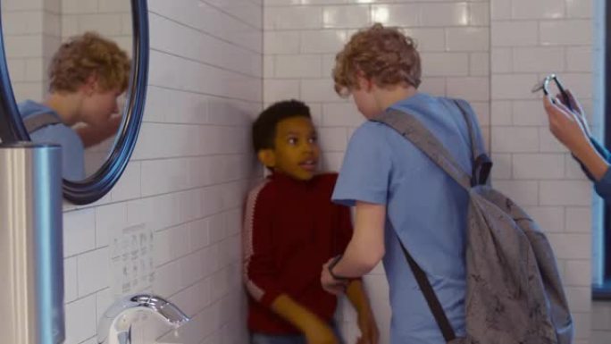 校园恶霸在浴室推搡殴打抑郁的非裔美国男孩。实时