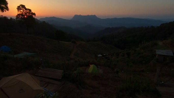 拉起镜头，夏天早晨在野生森林山上美丽的日出。