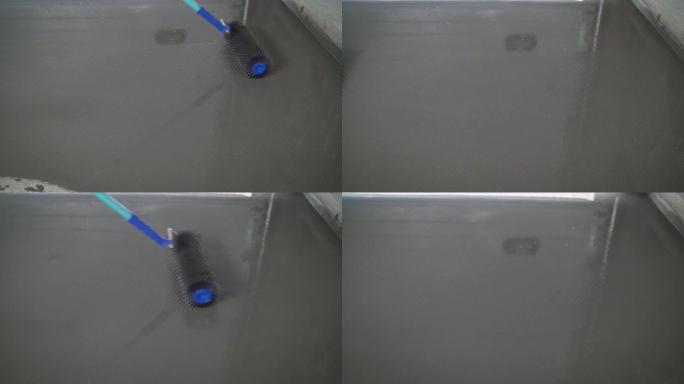 滚针是用于自流平地板的工具。自流平地板工艺。工人用滚针将地板水平