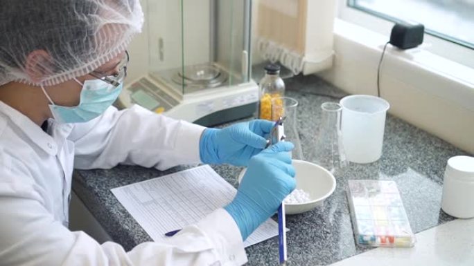 男性化学家在实验室Spbd中测量新制造的片剂的扣押。使发展