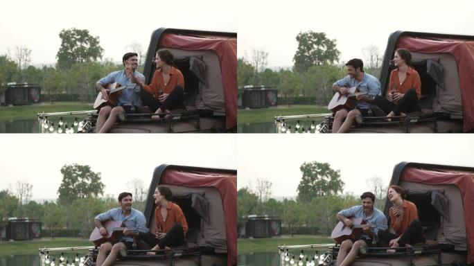 年轻夫妇弹吉他，唱歌享受露营。