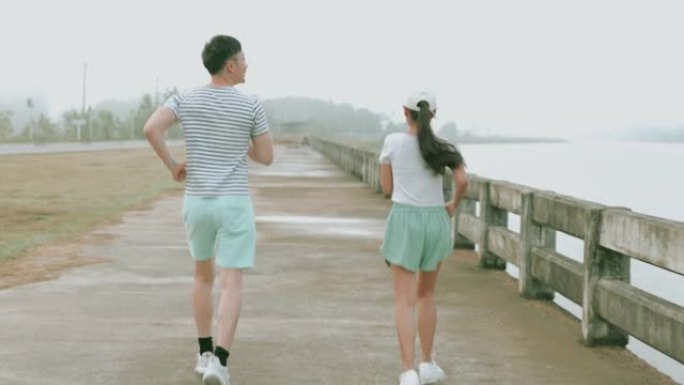 年轻夫妇在开始慢跑前轻拳，指向泰国的河流景观 -- 股票视频