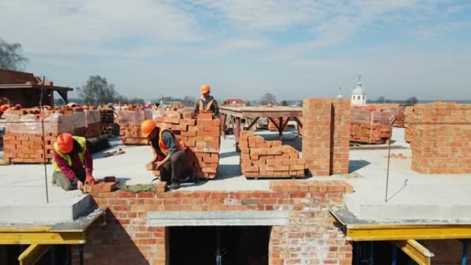两名建筑工人在多层建筑上铺设砖墙