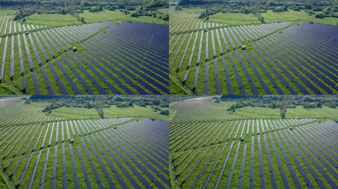 晴天在河附近绿地太阳能电站的鸟瞰图。飞越太阳能农场。太阳能电池板排成一排，用于发电。可再生绿色能源。