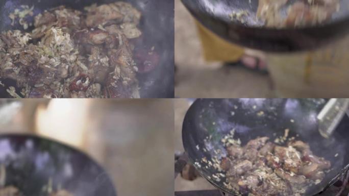 在炉子上的炒锅中用大蒜和黑胡椒炒鸭肉，用不锈钢刮刀在炒锅中用大蒜煮鸭肉