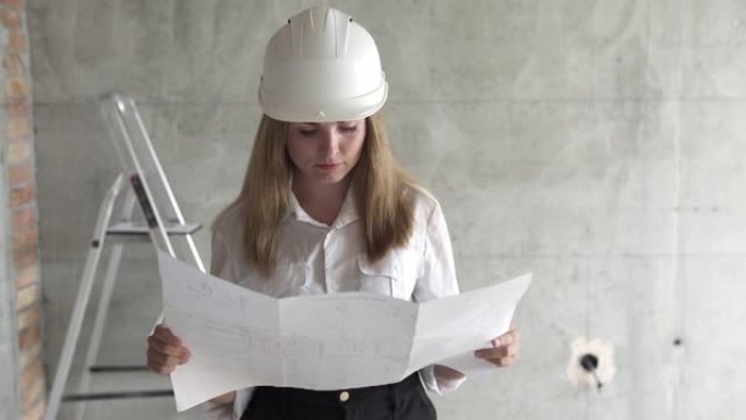 女工程师建筑商正在检查预计房屋公寓的图纸。