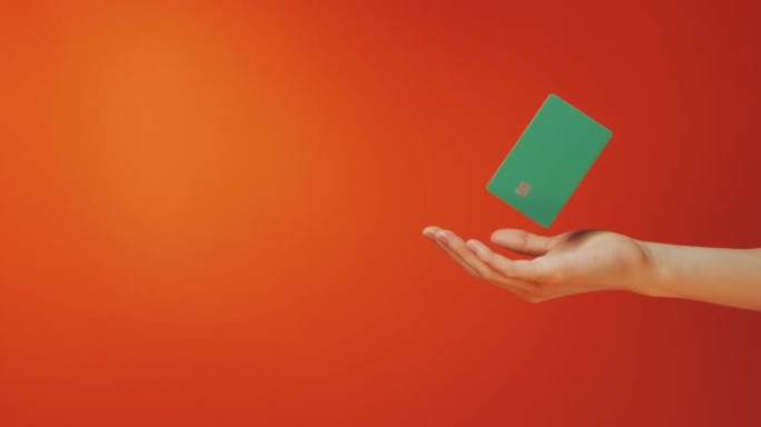 女性手握悬浮模板模拟银行信用卡在线服务孤立在橙色背景