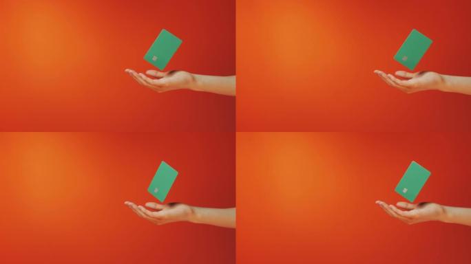 女性手握悬浮模板模拟银行信用卡在线服务孤立在橙色背景