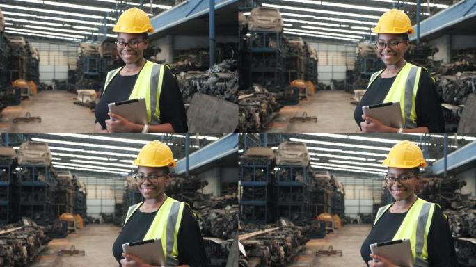 黑人女工带安全服头盔拿平板在工厂