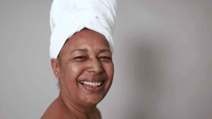 非洲高级女性在相机上微笑-美容日和护肤疗法概念