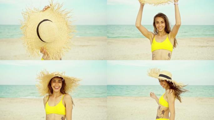 女人在多风的海洋海滩上拿着夏季草帽对着镜头