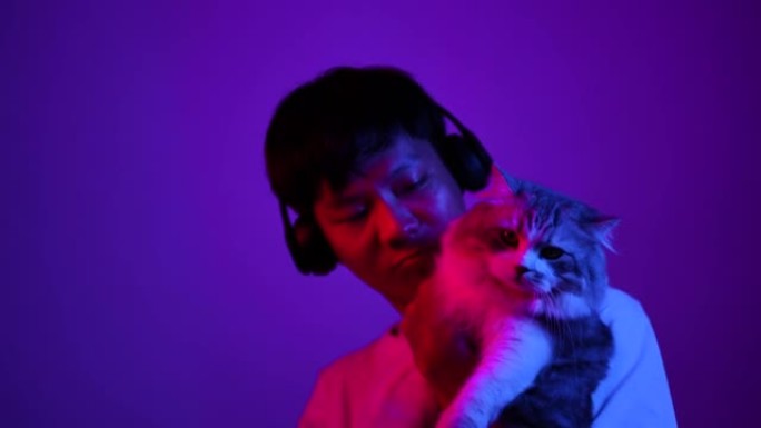 亚洲年轻人在霓虹灯下与猫一起跳舞