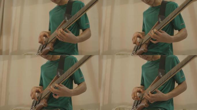对音乐的热情，年轻的亚洲男孩在客厅独自练习低音吉他的特写镜头-股票视频