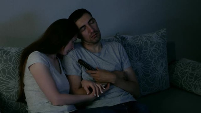 男人和女人在电视上看电影时睡着了