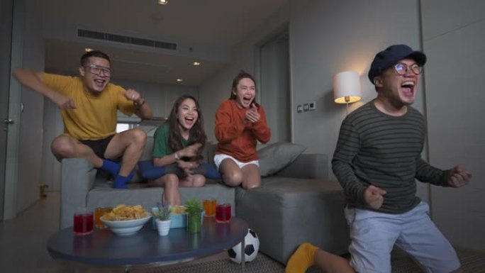 4k组亚洲人民朋友一起在家电视观看和欢呼比赛体育比赛