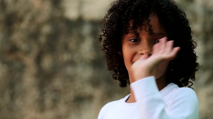 巴西小女孩向镜头挥手打招呼。儿童挥手嗨