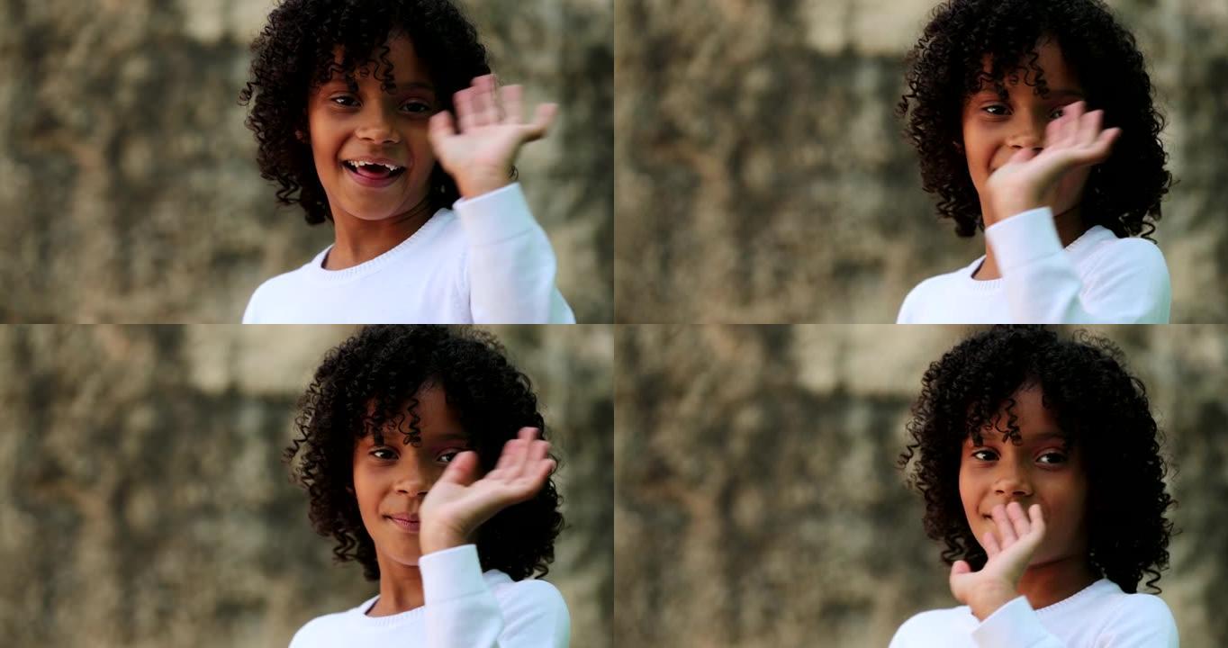 巴西小女孩向镜头挥手打招呼。儿童挥手嗨