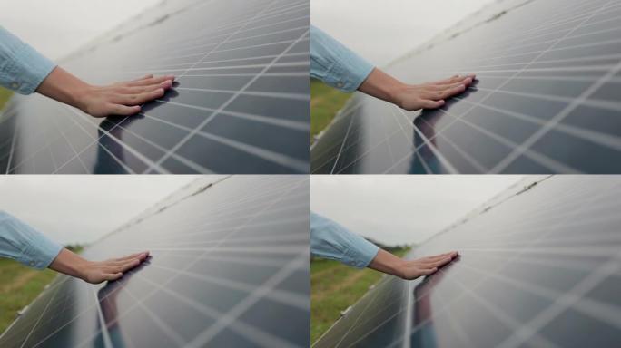 女工程师的特写镜头正在检查太阳能电池板。日落时工人的手和太阳能电池板。生态学概念。太阳能农场。清洁能