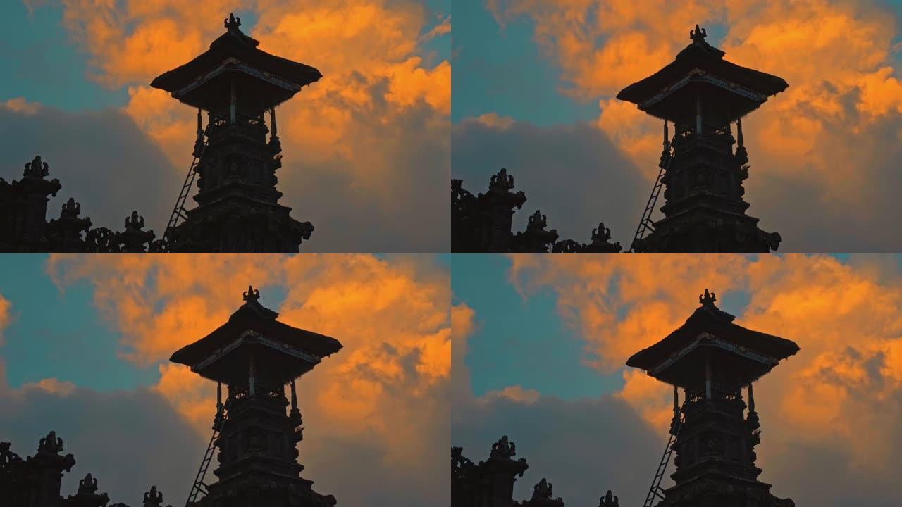 古老的印度尼西亚民族建筑，夜晚在黑暗中有一个稻草屋顶，日落时背景是红色的云彩和蓝天