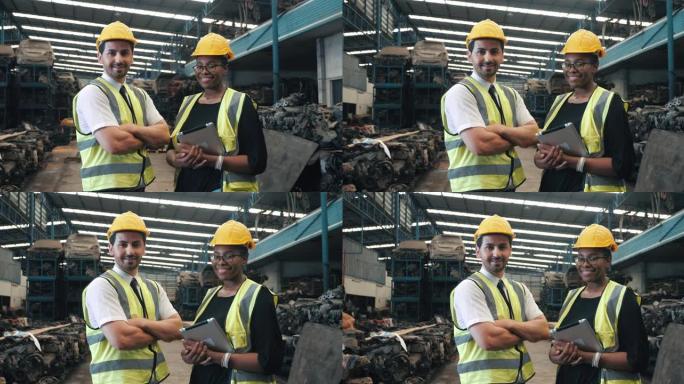 旧汽车配件厂两名带安全服头盔的工人机械师