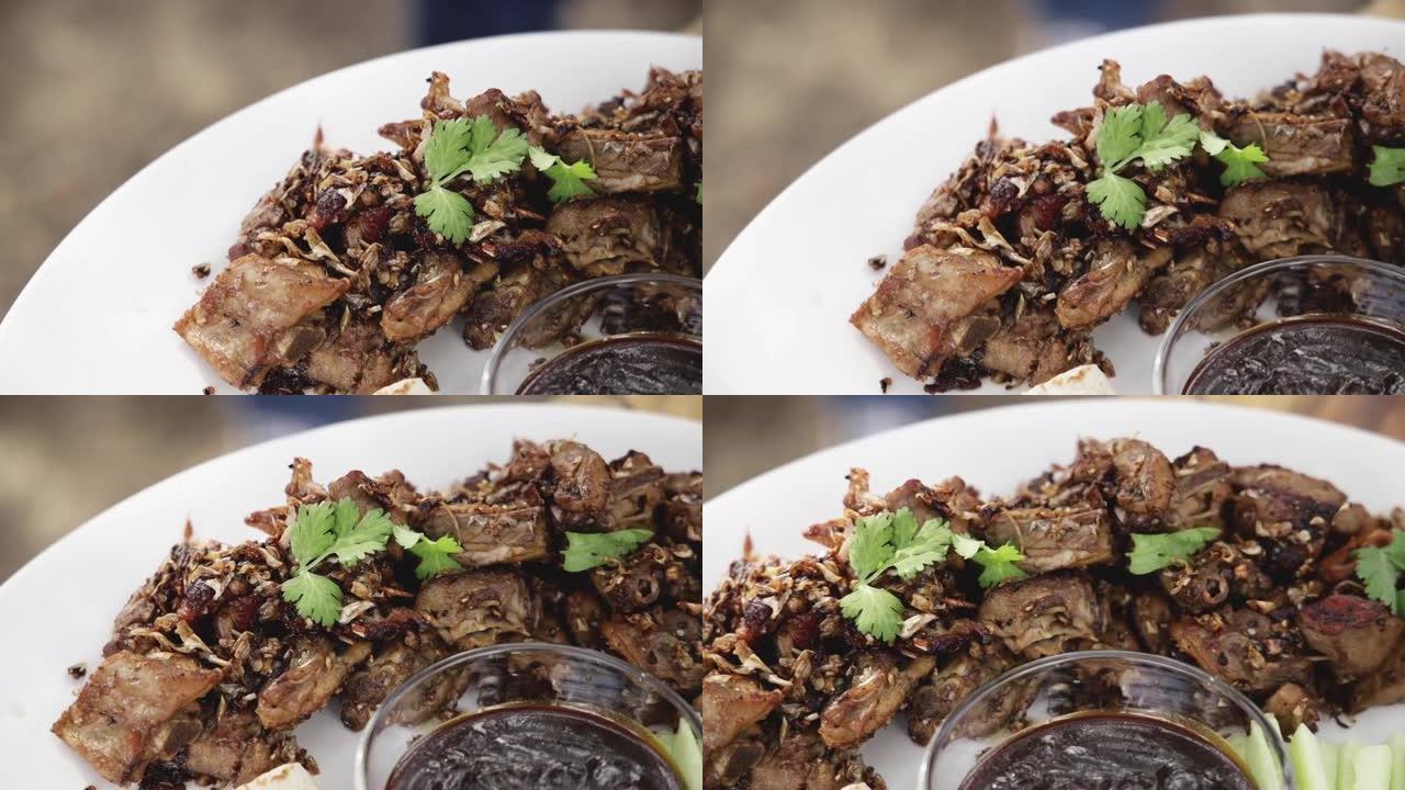 用大蒜和黑胡椒在白盘上炒鸭肉，用北京烤鸭酱，用蒜蓉煮熟的鸭肉放在玻璃碗里的酱汁盘子上