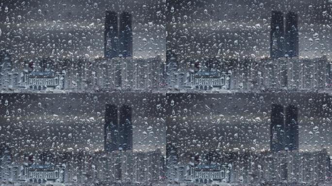 窗玻璃上的雨滴，背景建筑。