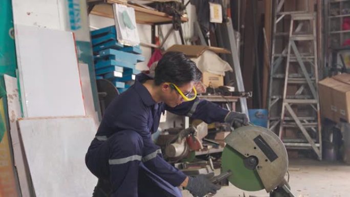 亚洲中国男性蓝领工人微笑着看着车间车库的镜头