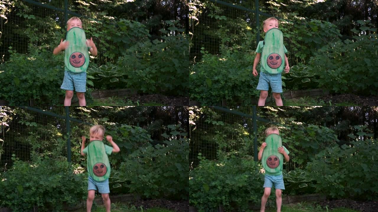 可爱的快乐小男孩，穿着手工鳄梨服装，在后院跳舞。素食，可持续的生活方式，健康的饮食理念。