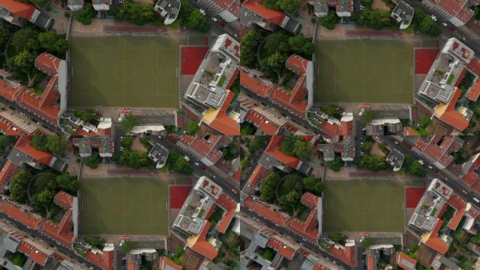 空中鸟瞰从上升的无人机俯视图。被建筑物紧密包围的足球场的火箭射击。德国柏林