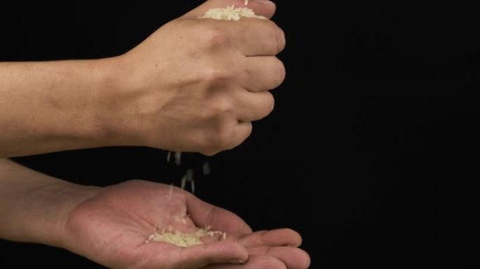 人的手握着并将一堆稻子倒在手掌中。