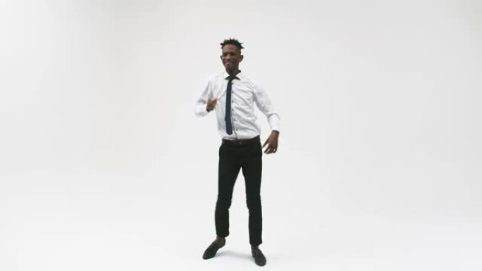 黑色皮肤的情感办公室男人站在白色背景上，跳舞很酷。工作室拍摄。情感表达的概念