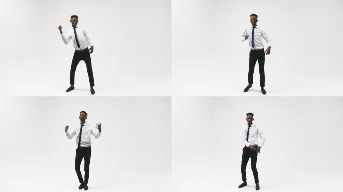 黑色皮肤的情感办公室男人站在白色背景上，跳舞很酷。工作室拍摄。情感表达的概念