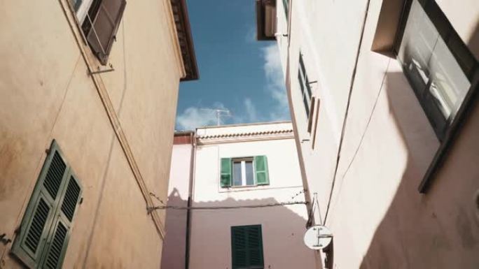 在晴朗的蓝天背景下，宏伟的建筑外部的低角度视图，维泰博省的意大利托斯卡纳小村，具有特色的建筑特色和观