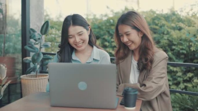 亚洲妇女在绿色办公空间的办公桌上使用笔记本电脑和数字平板电脑。