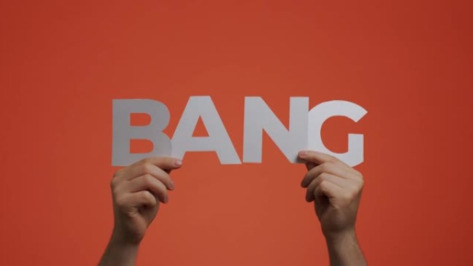 手显示由雕刻纸制成的英语单词Bang，用于博客屏幕保护程序，漫画
