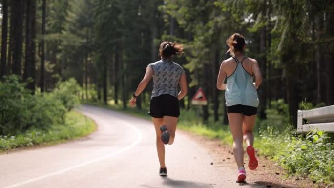 女运动员在森林中的道路上奔跑的背景图