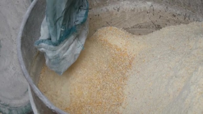 用于磨碎谷物的专用机器中的玉米麸或薄片。玉米面或切碎的玉米特写视图