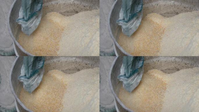 用于磨碎谷物的专用机器中的玉米麸或薄片。玉米面或切碎的玉米特写视图
