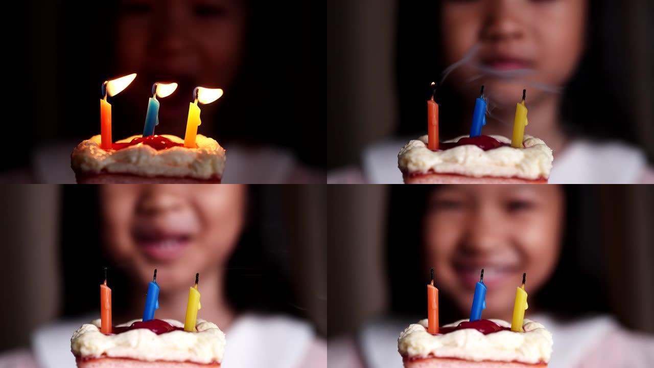 生日快乐蛋糕。可爱的亚洲儿童女孩在生日蛋糕上看着和吹蜡烛，感到快乐，享受，快乐。庆祝和幸福的概念。