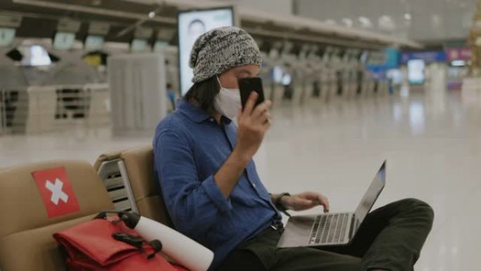 中年成人亚洲男子戴着防护面罩，在接电话前整理好他的东西，并查看一些电子邮件-股票视频