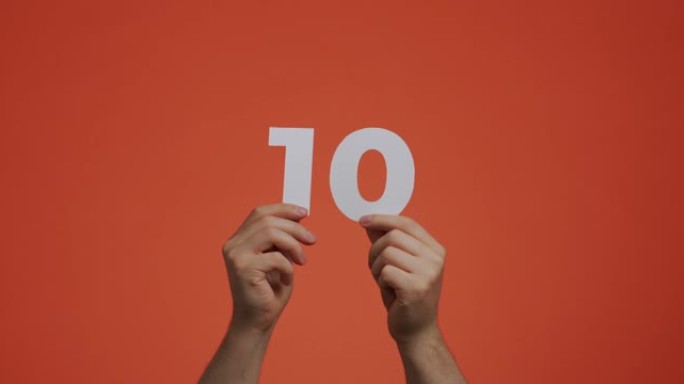 手中有十号。显示数字的人，10个由雕刻纸制成的数字，用于投票或数学学习