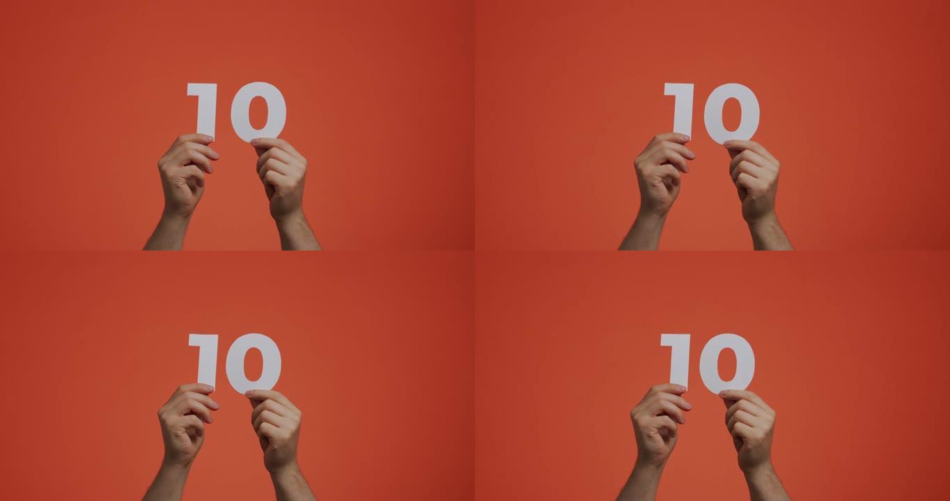 手中有十号。显示数字的人，10个由雕刻纸制成的数字，用于投票或数学学习
